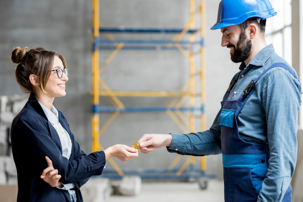 Woman giving cryptocurrency to a builder